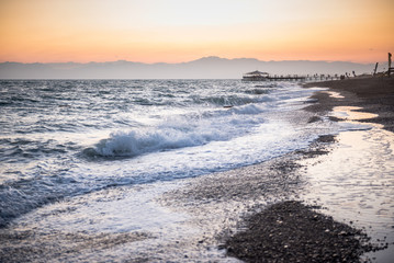 Fototapeta premium Waves from the sea at a beach in sunset