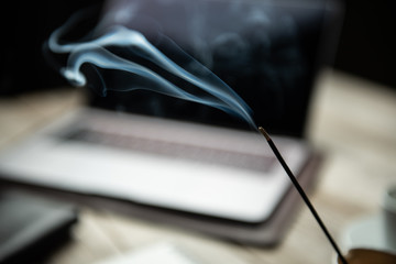  incense on blurred background of businessman workplace on old wooden table