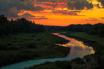 Beautiful sunset over a river with green bushes