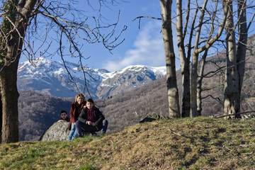 Fototapeta premium mother with her children rest on a rock along an alpine path
