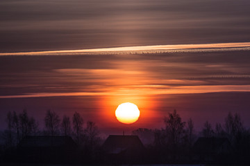 Sunset in a cold winter evening over a meadow