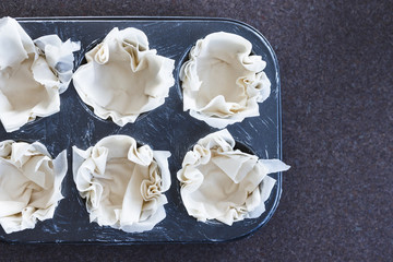 homemade food, filo pastry in muffin tray ready for filling