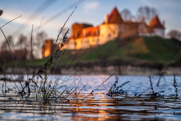 Bauska city castle up in the hill next to river