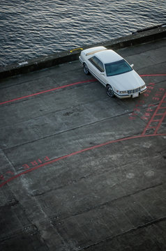 White Car Parked Next To Water In A Dock