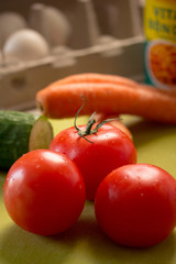 Tomatoes, cucumbers, carrots and eggs on a table