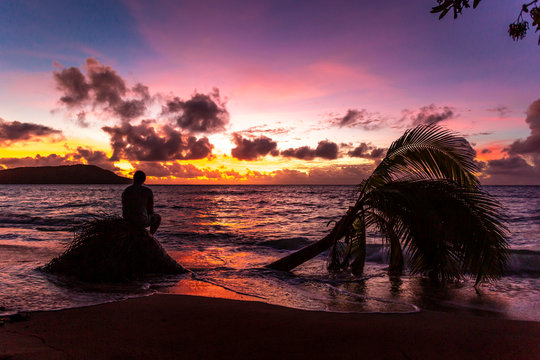Silhouette shot of a man from behind watching a gorgeous beach sunset