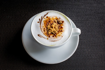 A cup of hot art coffee on black background.