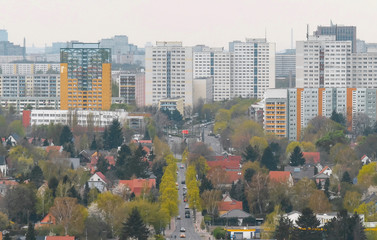 Fototapeta na wymiar Cottages and the big city. The road to the big city. small, comfortable, European private houses and large multi-story residential buildings. Suburb. Panorama, landscape of the city. Lots of trees.