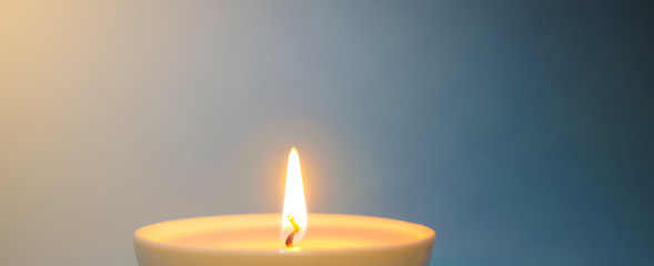 Burning candle wick close-up, macro. Festive, New Year's, green wax candle burns slowly against a...