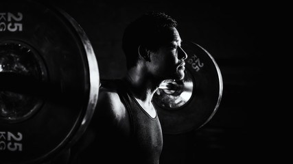 asian strong athletic man having workout and bodybuilding with barbells weight lifting backsquat...