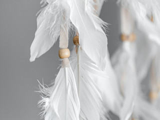 Plumage and beads of a Native American Dreamcatcher. Close up. Selective focus.