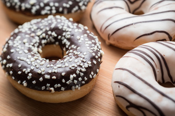 Black and white chocolate doughnuts on a wood table