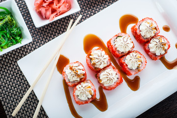 Uramaki sushi ikura maki with chilli sauce