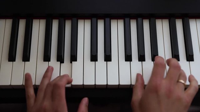 Playing piano chords on a full weighted keys piano with both hands making musical melodies - 50fps