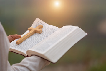 Young women study the scriptures. The sunrise background or whether the sunset The educational concept of Christian Tipitaka that is open and praying to God