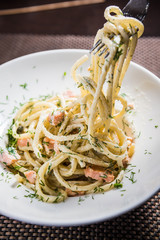 Spaghetti carbonara on a white dish with dill