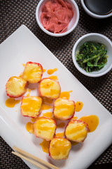 Hot sushi fritter maki on a white plate