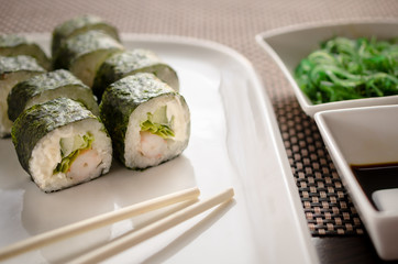 Sushi uramaki rolls with tiger prawns, cucumber