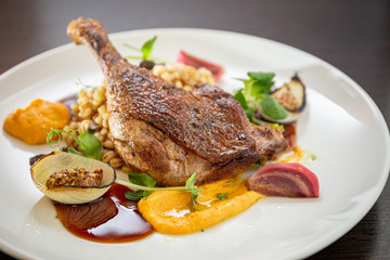 Grilled duck leg with pearls, vegetables, onions