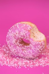 Donut pink.Baking and sweets. Pink bite donut on a  sweet decor on a bright fuchsia...