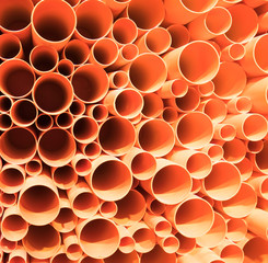 orange PVC pipes stacked in construction site