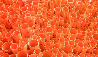 orange PVC pipes stacked in construction site