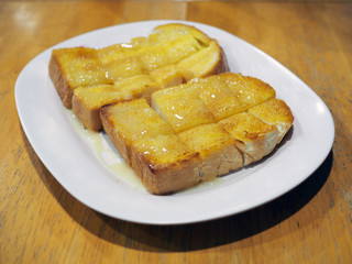 Plate of toast spreaded with butter, condensed milk and sugar. Popular snack in Thailand.