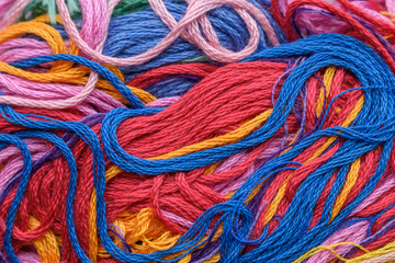 Multicolor threads for backdrop. Chaotic disposition, twisting, villi. Close-up. Color - red, blue, orange, violet, yellow.