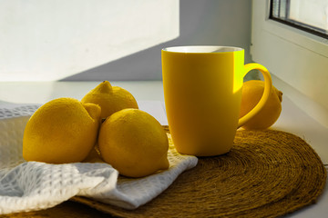 Bright yellow lemons and a mug
