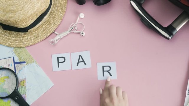 Top view hands laying on pink desk word PARIS