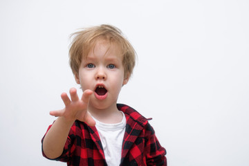 Child 3-4 years old with a surprised open mouth pulls his hand forward to meet the camera on a white background.