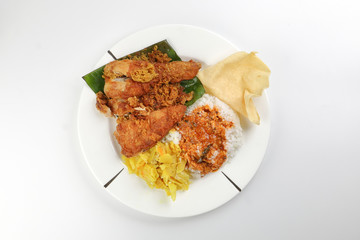 Traditional Malaysian Indian food white rice cabbage vegetable meat deep fried chopped chicken leg topped up with spicy mix gravy white background