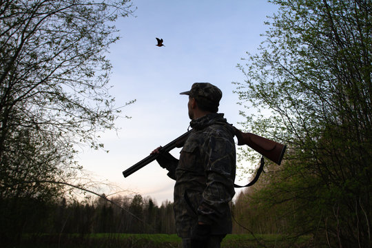 a hunter looks at a flying woodcock late at night