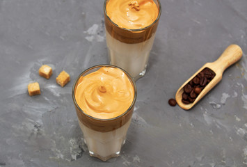 Dalgona coffee. Korean coffee in two glasses with brown sugar, coffee on  white background. Drink cold milk. Top view. Copy space