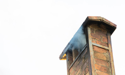 Smoke from chimney on roof of the house