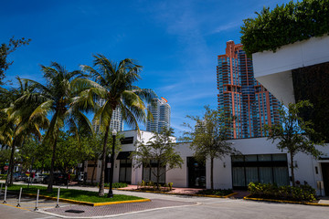 Fototapeta na wymiar Miami Beach Street. Florida, USA. South Beach. Buildings and palm trees. Small buildings and skyscrapers nearby. Summer in Florida south city.