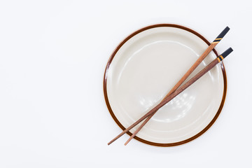 Isolated of Wooden chopsticks on ceramic plate