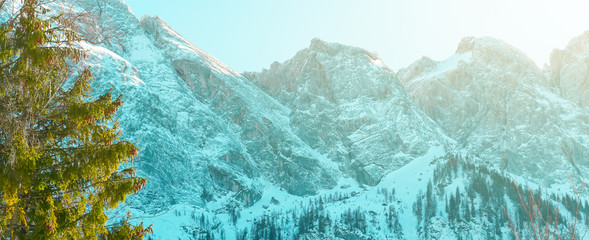 Alpine summits. Peaks of snowy Alpine mountains under the rays of the sun on a clear day with a...