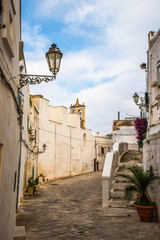 Fototapeta na wymiar A public street with traditional houses in the old town area of the city center in Ostuni, South Italy