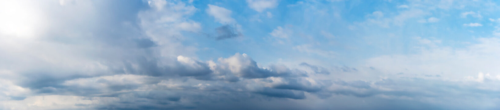 Clouds on a clear Sunny spring sky as a background. Panoramic view.