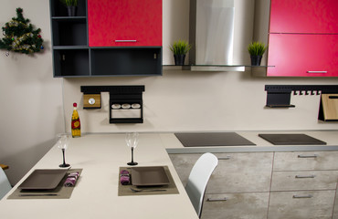 modern loft-style kitchen with red cabinets, stove, range hood and table with countertop