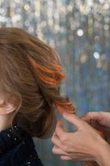 Fototapeta premium Hairdressing services. Creation of evening hairstyles fashionable stylish women's hairstyles. Hair styling process. Side view. Elegant multi colored hairstyle. Creative trendy coloring.