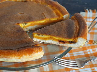 Home cooking.Orange pumpkin round pie. Natural vegetarian dessert on a dark wooden background.