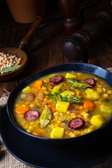 Rustic pea soup with bacon and sausages