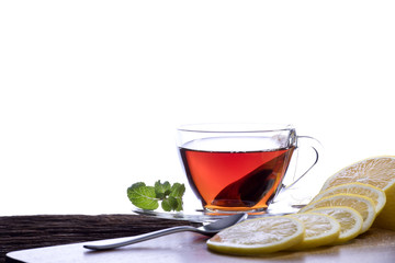  Tea in transparent glass cup with lemon on white background