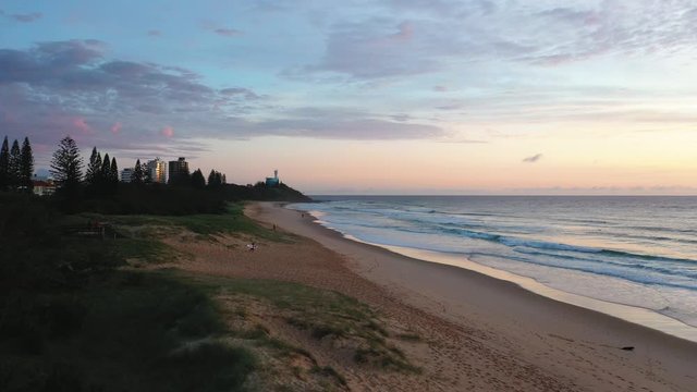 Sunrise and Running Surfer at Sunshine Coast, Buddina, Queensland, Australia.