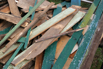 A pile of old boards with paint residue and nails sticking out

