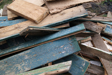 A pile of old boards with paint residue and nails sticking out
