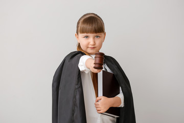 Portrait of little judge on grey background