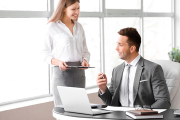 Boss and his beautiful secretary working in office